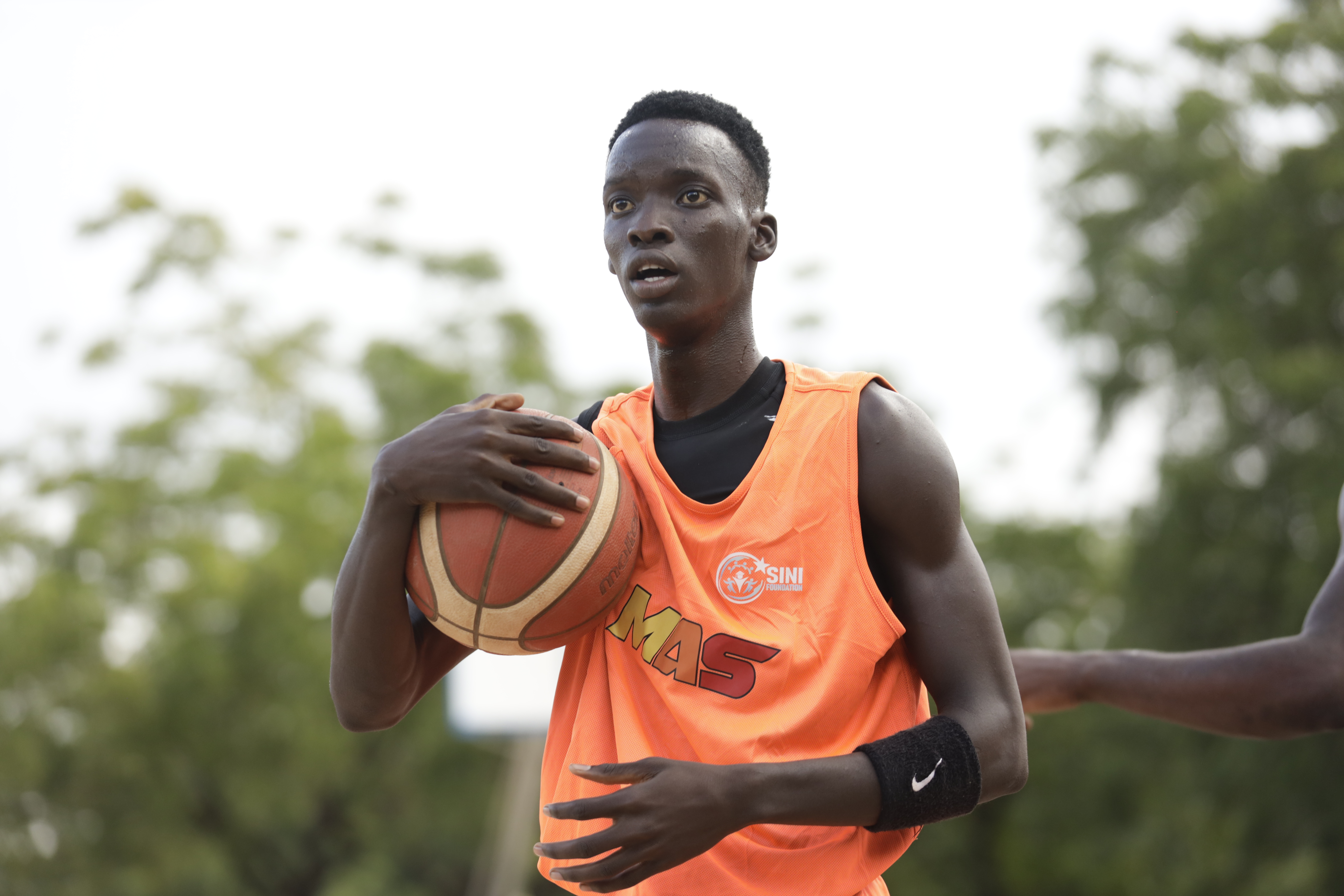 Basketball scouts observing youth players during training session in Africa